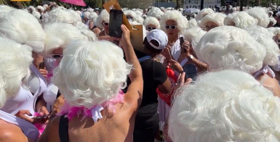 Menigte met witte pruiken op straat