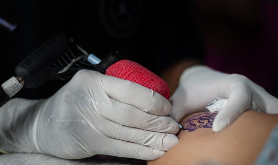 Tattoo-artiest zet tattoo met machine op huid