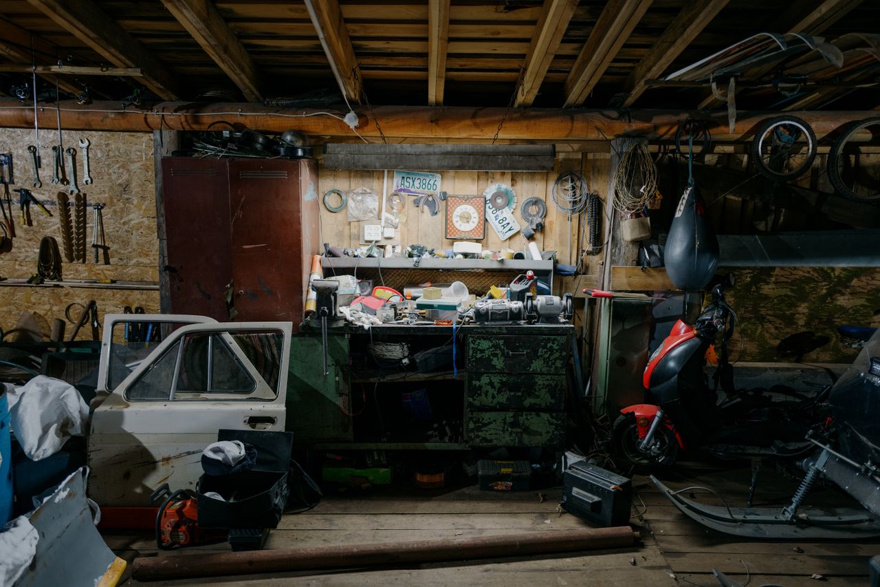 Rommelige garage met werkbank, gereedschap en scooter