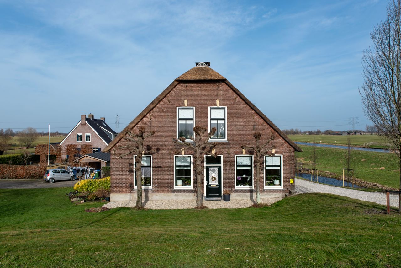 Traditionele bakstenen boerderij met rieten dak