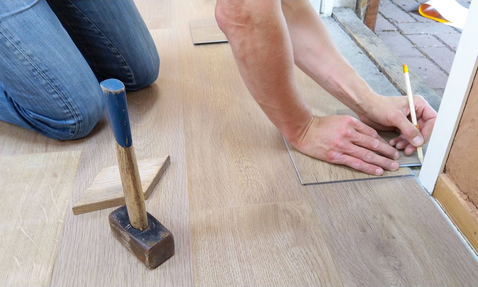 Vakman meet en markeert planken van een houten vloer