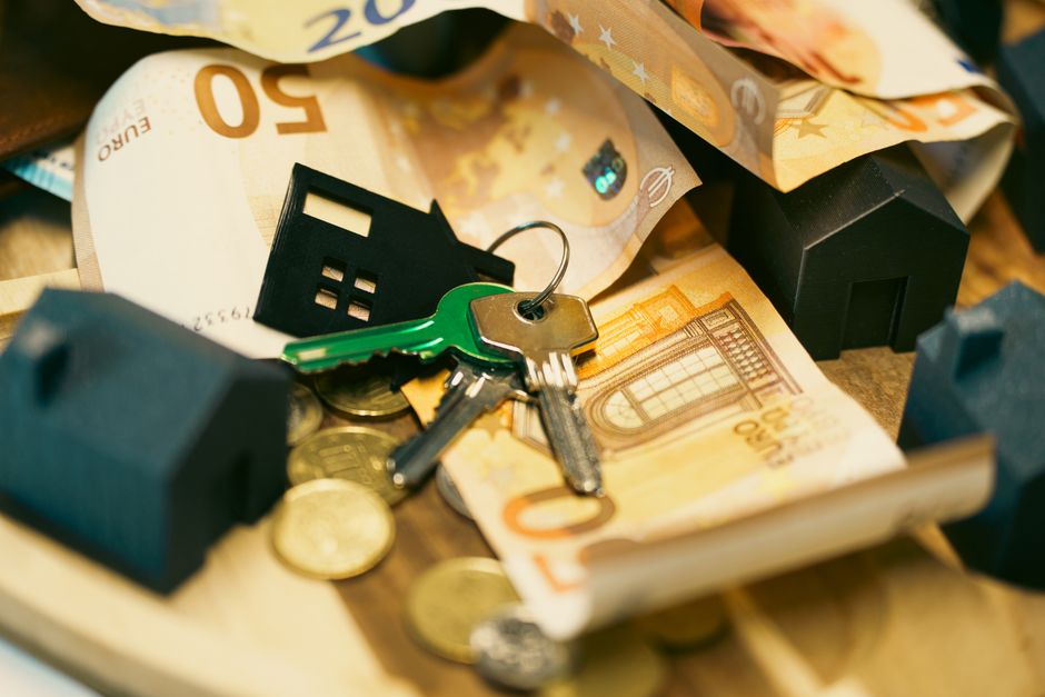 Miniatuurhuisje tussen eurobiljetten en munten